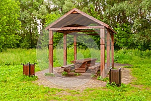 Wooden arbour a background of green trees