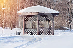 Wooden arbour in the snow-covered park
