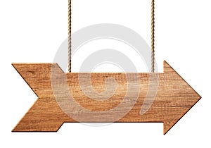 Wooden arrow shape signpost or signboard made of natural wood hanging on ropes