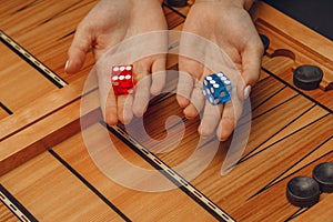 Wooden backgammon and girl`s hands with bones