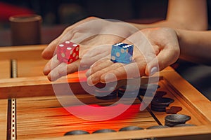 Wooden backgammon and girl`s hands with bones