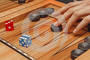 Wooden backgammon and girl`s hands with bones