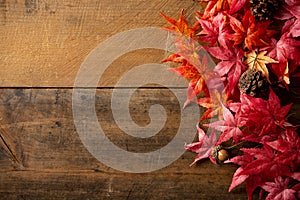 Wooden background with artificial autumn maple leaves.