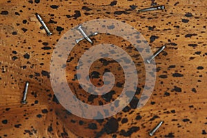 Wooden background with black spots and hammered nails