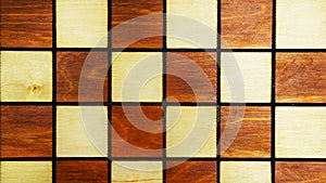 Wooden background of a chessboard close-up. Vintage texture of a chess Board. White and black squares