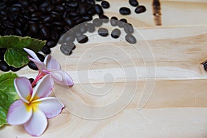 Wooden background Decorated with coffee beans, frangipani flowers and leaves