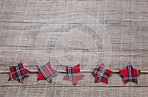 Wooden background decorated with red christmas stars of fabric.