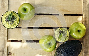 Wooden background with green detox smoothie and fruits