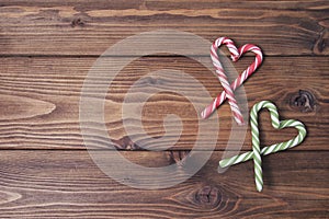 Wooden background with hearts of Christmas candy can