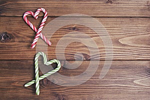 Wooden background with hearts of Christmas candy can