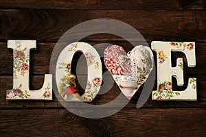 Wooden background with inscription created with diy letters LOVE and a heart in the place of V letter