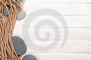 Wooden background with marine rope and sea stones