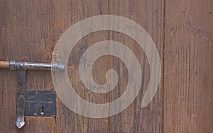 Wooden background of an old door with a bolt and lock from the same period