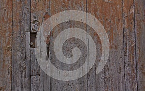Wooden background of an old door with a knocker from the same period