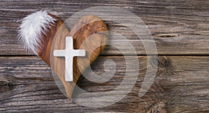 Wooden background with olive heart and white cross for an obituary notice. photo