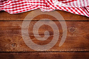 Wooden background with red plaid napkin