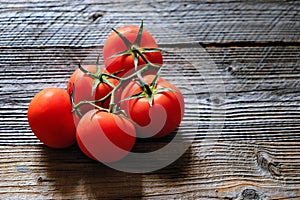 Wooden background with red washed tomatoes in left side. Copy space. Top view.