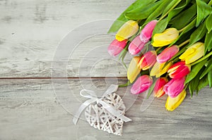 Wooden background with tulips and heart