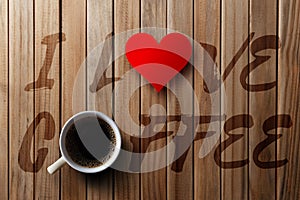 Wooden background, written I love coffee, with a cup of coffee.