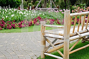 Wooden bamboo bench in flower garden