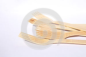 Wooden bamboo cutlery forks on bright white background