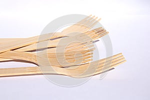 Wooden bamboo cutlery forks on bright white background