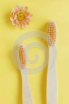 Wooden bamboo toothbrush on yellow background photo