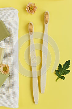 Wooden bamboo toothbrush on yellow background photo