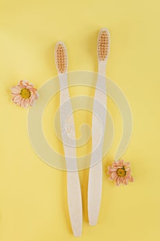 Wooden bamboo toothbrush on yellow background photo