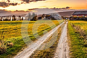 Wooden barn with farmhouse at sunset in Norway