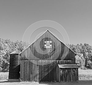 Wooden barn in sunshine with quilt