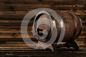 Wooden barrel with iron rings on a brown wooden background