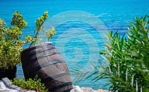 Wooden barrel of pirated gold and money against nautical landscape. Copy space