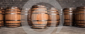 Wooden barrels in cellar backgound, empty space on barrel for advertising. Old Wooden barrels with wine in wine vault. wide banner