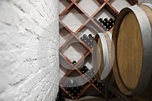 Wooden barrels on stand in wine cellar, closeup