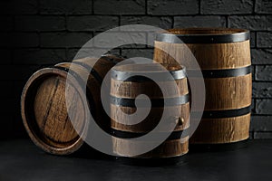 Wooden barrels on table near brick wall, closeup