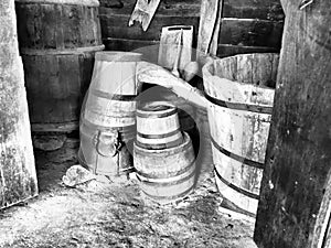 Wooden barrels and tubs in the barn. Household old utensils. Farming. Double retro wooden bathtub with water topping