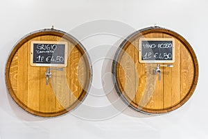 Wooden barrels for wine with a tap in wine shop. Close-up. Wine for bottling. Price for one liter wine. Top view