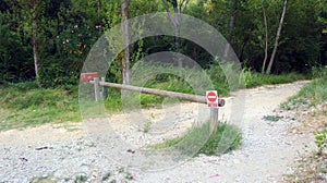 Wooden barrier in the forest with a red sign photo