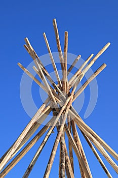 The wooden base of the Nenets dwelling against the blue sky in Siberia