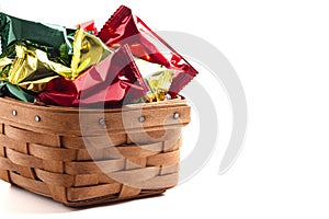 A Wooden Basked Filled with Foil Wrapped Chocolate Truffles Isolated on a White Background