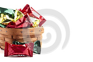 A Wooden Basked Filled with Foil Wrapped Chocolate Truffles Isolated on a White Background
