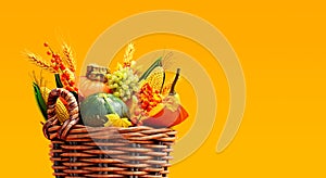 Wooden basket full of autumn fruits and vegetables on orange background