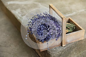 Wooden basket with lavender flowers on cement floor