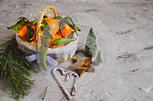 Wooden Basket Mandarine with Leaves and Lights, Tangerine Orange on Gray Table Background Christmas New Year Decors