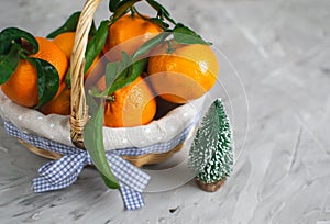 Wooden Basket Mandarine with Leaves and Lights, Tangerine Orange on Gray Table Background Christmas New Year Decors