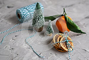 Wooden Basket Mandarine with Leaves and Lights, Tangerine Orange on Gray Table Background Christmas New Year Decors