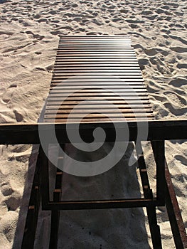 Wooden beach chairs on white sand beach in Thailand