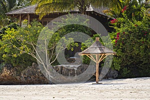 wooden beach parasol and garden on the back at luxurious beach resort