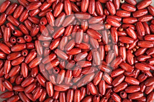 Wooden beads, accessories for needlework. Red wooden beads background.